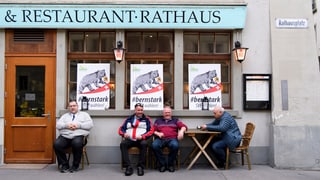 Vier Männer sitzen vor dem Restaurant Rathaus
