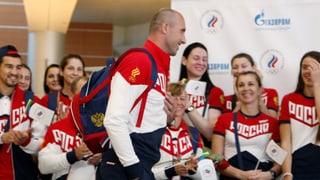 Sergej Tetjuchin läuft lachend an einer Gruppe Fans vorbei.