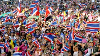 Menschenmenge mit thailändischen Flaggen.