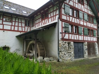 Mühle mit Riegelbau und Mühlenrad.