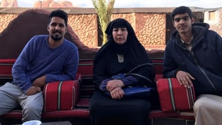 Frau und zwei Männer sitzen nebeneinander Frau und zwei Männer sitzen nebeneinander