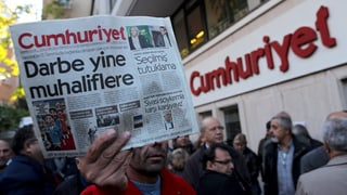 Eine Person hält eine Zeitungsexemplar vor der Redaktion der «Cumhuriyet» in der Hand.