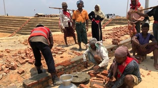 Handwerker in einem Flüchtlingslager beim Häuser bauen.