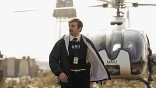Ein Mann in Polizeimontur steht vor einem Helikopter.