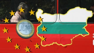 Ein Mann sitzt in einem Bus. Auf dem ist eine Euro-Münze, die Sterne der EU-Flagge und die Farben der bulgarischen Flagge zu sehen.