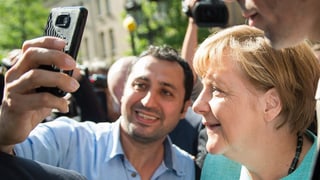 Merkel beim Selfie mit einem Flüchtling.