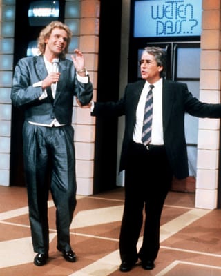 Im Studio: Links Thomas Gottschalk in silbrigem Anzug, rechts Frank Elstner in schwarzem Anzug. 