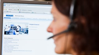 Eine Frau mit Headset an einem Bildschirm mit Medgate-Logo oben links. Eine Frau mit Headset an einem Bildschirm mit Medgate-Logo oben links.