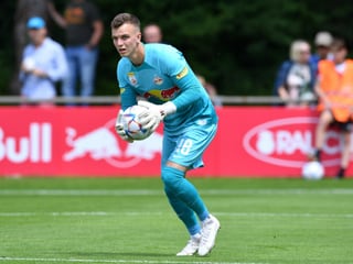 Goalie Philipp Köhn fängt einen Ball im Trikot von Red Bull Salzburg.