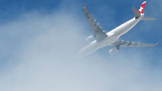 Flugzeug der Airline Swiss von unten fotografiert fliegt in eine Wolke