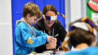 Herzogin Catherine versucht mit verbundenen Augen, etwas zu essen.