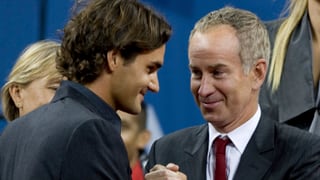 John McEnroe schüttelt Roger Federer die Hand.