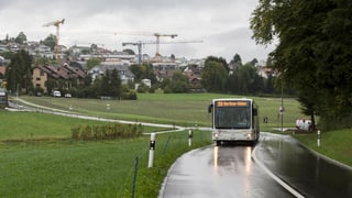 Bus fährt auf einer Hauptstrasse bei Oberwil-Lieli im Regen.