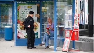 Mann mit Rosen in der Hand spricht mit einer Polizistin