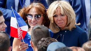 Macron mit einer Frau aus dem Volk und mit Frankreich-Fähnchen.
