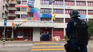 EIn Polizist steht vor dem besetzten Haus. EIn Polizist steht vor dem besetzten Haus.