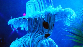 Björk mit weissem Stoffhut und Stoffmaske.