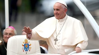 Papst Franziskus winkt aus dem Papamobil der Menge zu. 