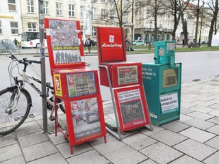 Drei Zeitungsautomaten mit den jeweiligen Titelblättern der Zeitungen. 