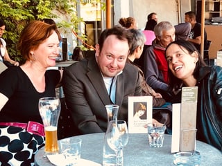 Joe Goebel, Ruth Geiger und Annette König sitzen an einem Tisch und lachen in die Kamera