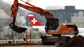 Bagger vor einem Flugzeug der Swiss in Kloten.