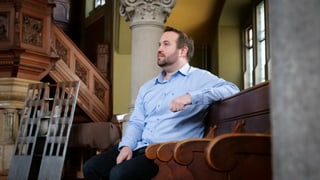 Renato Pfeffer sitzt in einer Kirche. Er trägt ein blaues Hemd. Renato Pfeffer sitzt in einer Kirche. Er trägt ein blaues Hemd.