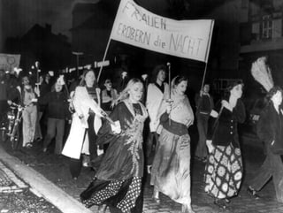 Eine Demo von Frauen in Hexenkostümen, mit Fackeln und einem Banner «Frauen erobern die Nacht».