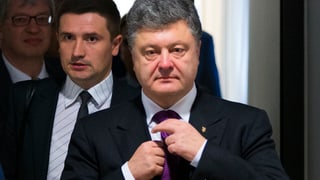 Poroschenko richtet seine Krawatte.