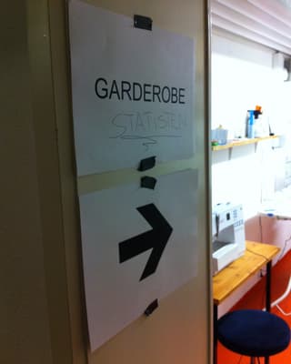 Ein Schild mit der Aufschrift «Garderobe» mti der handschriftlichen Ergänzung «Statisten».