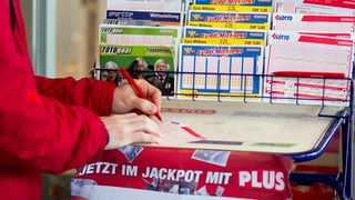 Eine Frau füllt einen Lotto-Schein aus. Eine Frau füllt einen Lotto-Schein aus.