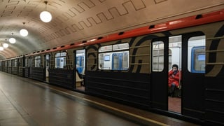 U-Bahn in einer Station, eine Person sitzzt drin, hält die Hand an den Mundschutz U-Bahn in einer Station, eine Person sitzzt drin, hält die Hand an den Mundschutz