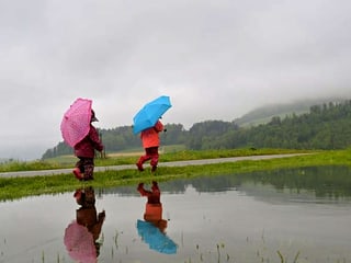 Zwei Kinder im Regen.