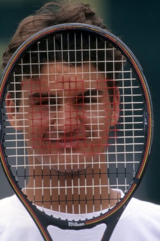 Tennisspieler hält Schläger vor den Kopf.