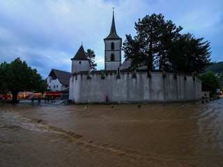 Braunes Wasser am Boden, im Hintergrund eine Kirche