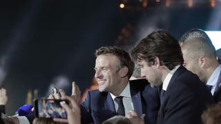 Frankreichs Präsident Emmanuel Macron jubelt mit Wählerinnen und Wählern.