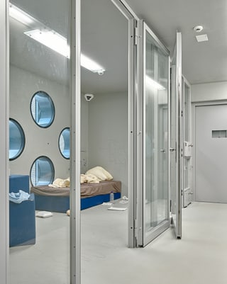 Eine Gefängniszelle hinter Glastüren.