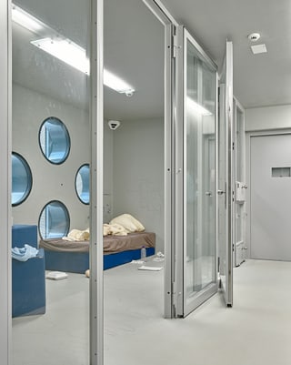 Eine Gefängniszelle hinter Glastüren. Eine Gefängniszelle hinter Glastüren.