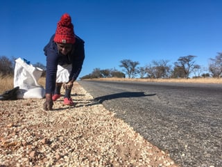 Glück gehabt: Craina Mukundwi findet Maiskörner, die ein Transporter verloren hat.