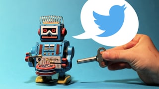 Eine Hand steckt einen Schlüssel in einen mechanischen Roboter, der dabei tweetet.