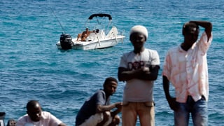 Europäische Wirklichkeit: Während ein Mann auf dem Mittelmeer fischt und die Sonne geniesst, warten gestrandete Flüchtlinge an der Grenze zwischen dem italienischen Ventimiglia und dem französischen Menton.