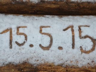 Auf Holz steht das Datum von Hand in den Schnee geschrieben.