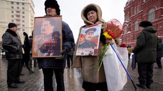 Zwei alte Russen tragen Bilder von Stalin durch die Strassen von Moskau Zwei alte Russen tragen Bilder von Stalin durch die Strassen von Moskau