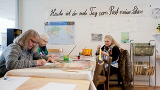 Drei Frauen sitzen an einem Tisch und malen. Drei Frauen sitzen an einem Tisch und malen.