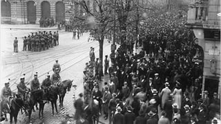 Tausende Arbeiterinnen und Arbeiter versammeln sich 1918 auf dem Paradeplatz in Zürich und demonstrieren..
