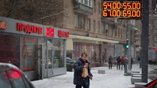 Mann überquert die Strasse, im Hintergrund digitale Anzeige von Währungskursen. Mann überquert die Strasse, im Hintergrund digitale Anzeige von Währungskursen.