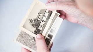 Eine Hand zeigt auf ein altes Foto Eine Hand zeigt auf ein altes Foto