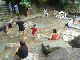 Leute die im heissen Fluss bei Beitou baden.