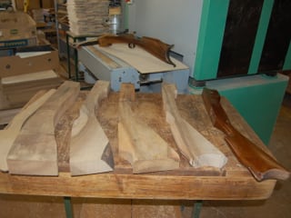 Holzstücke in unterschiedlicher Bearbeitungsstufe bis zum Armbrust-Schaft.
