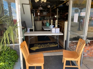Ein Tisch steht vor einem Restaurant-Eingang. Ein Tisch steht vor einem Restaurant-Eingang.