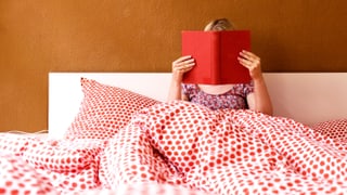 Eine Frau liest im Bett.